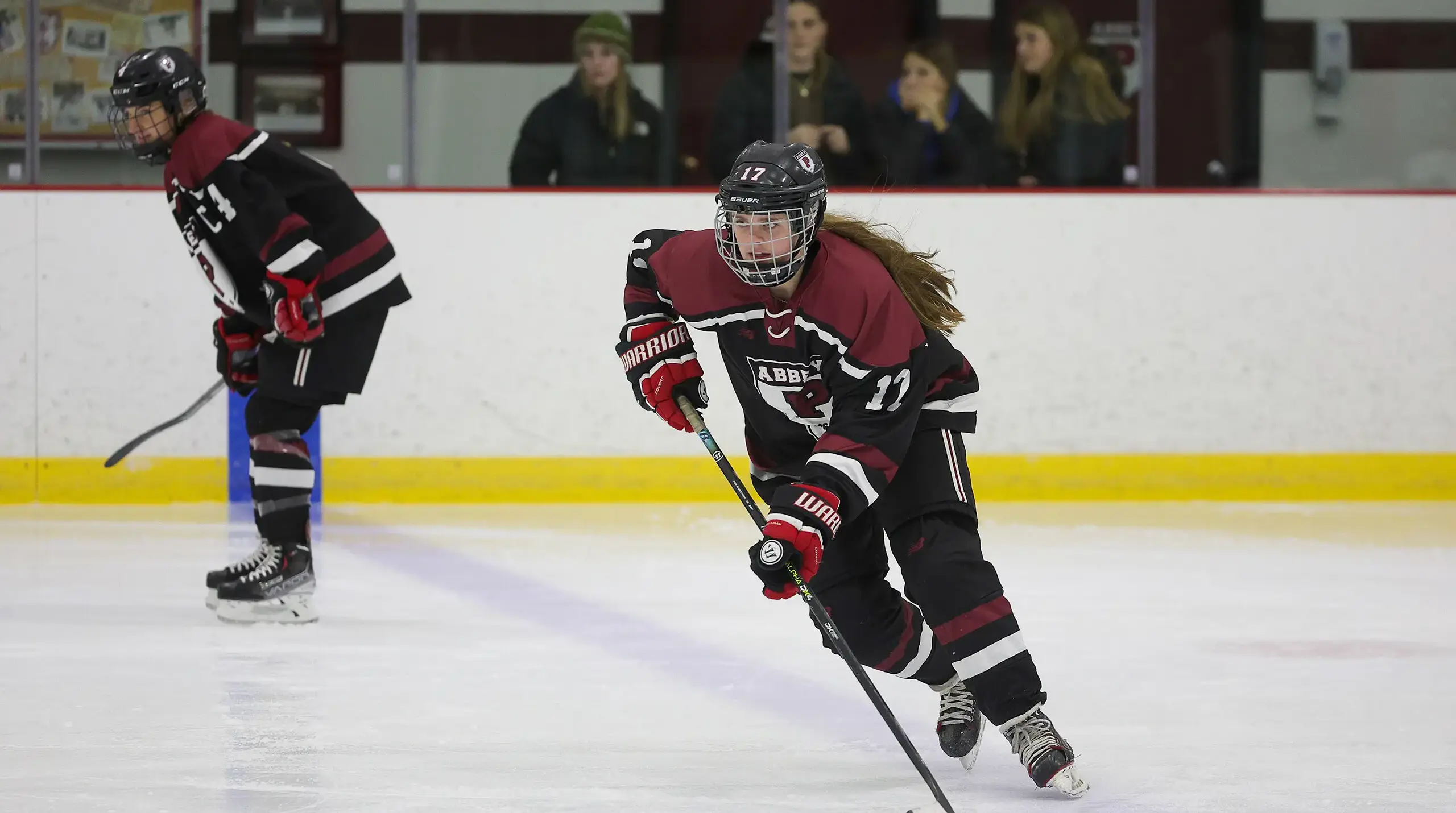 Girls varsity hockey player skating on the ice.