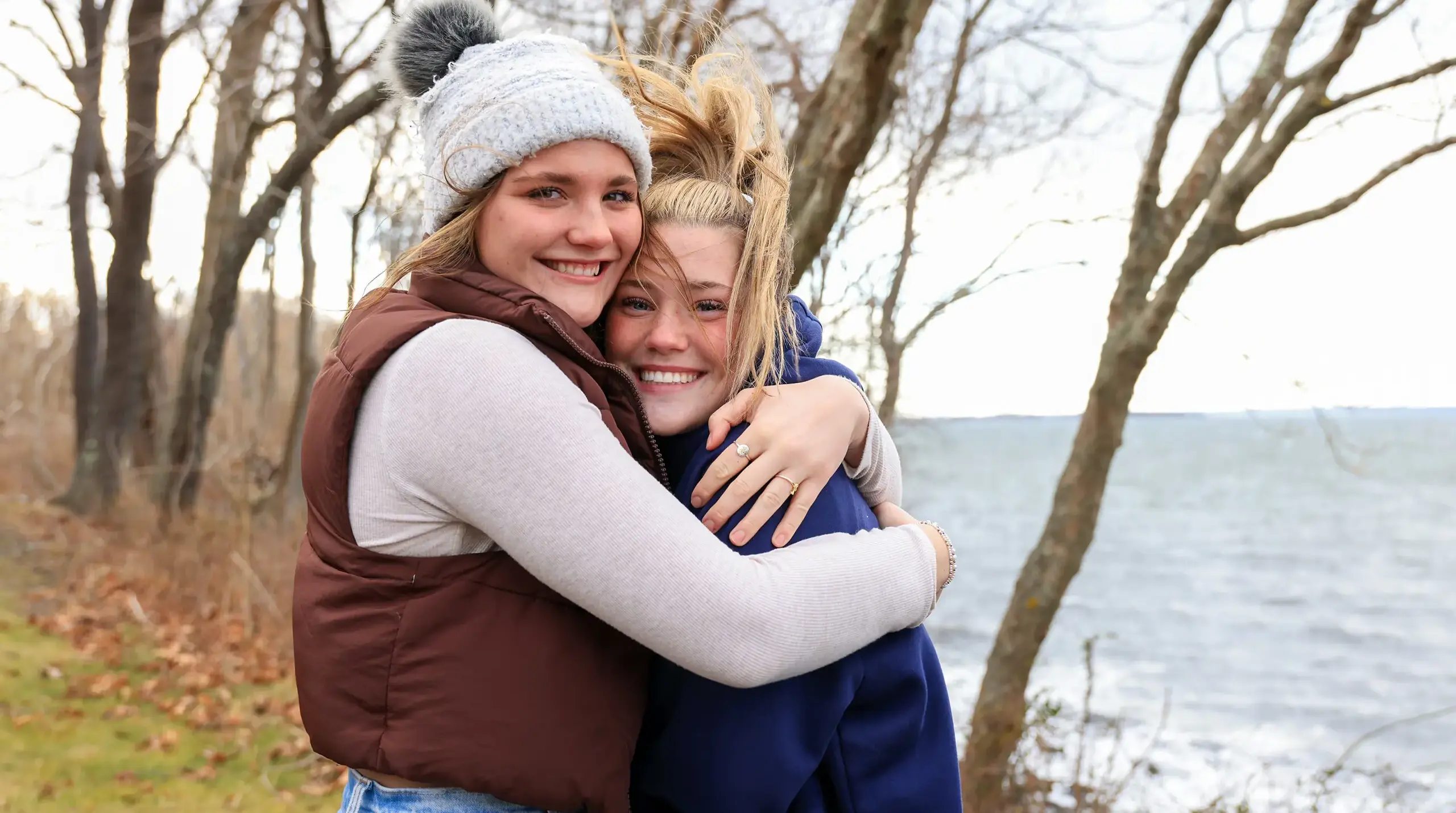 Two girls hugging outdoors.